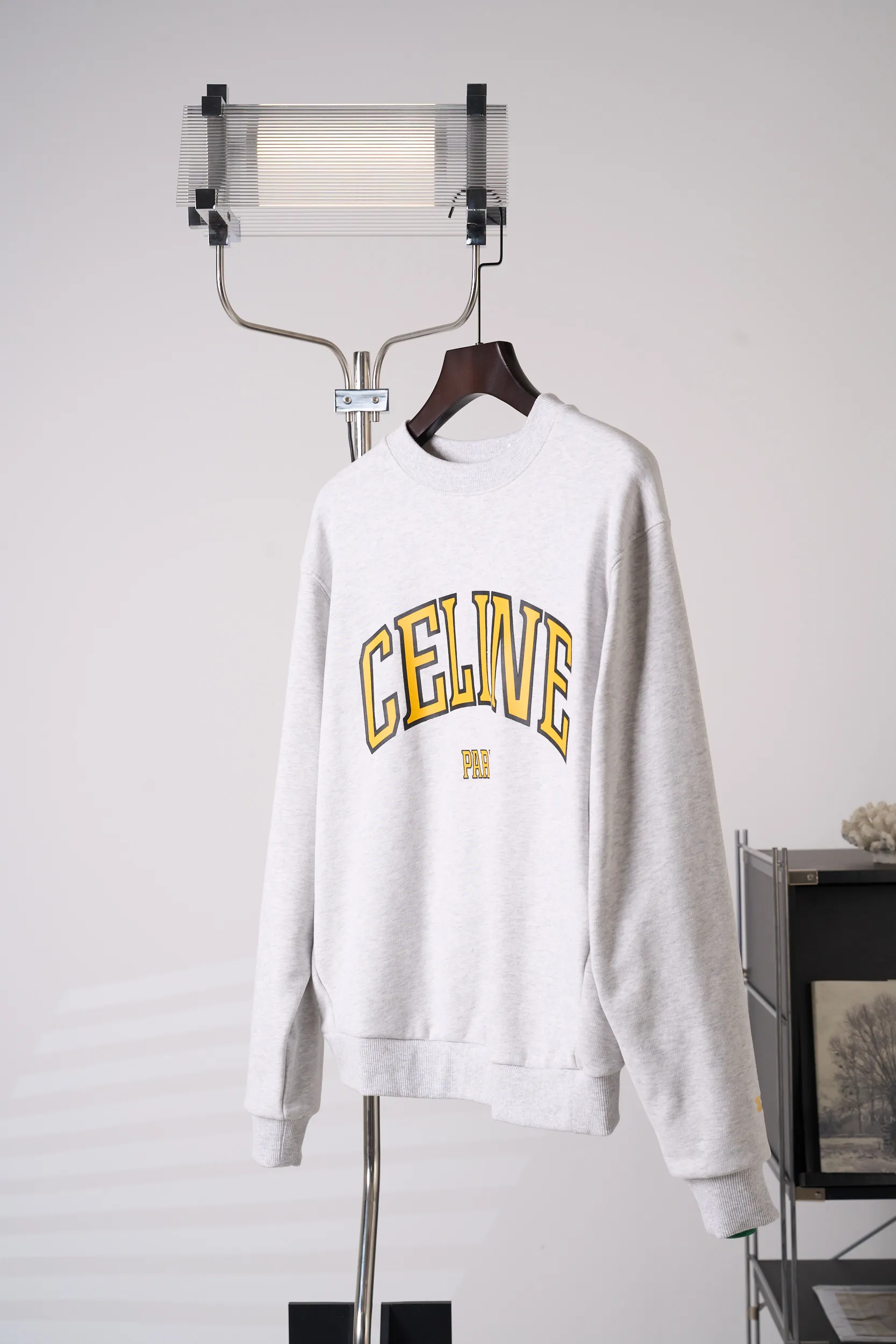[Real auction] Celine/Céline Paris letter printed logo round neck sweatshirt (women's style) [In Stock] S M L custom-dyed densely woven fish scale sheared cotton material, fine and fluffy, soft and skin-friendly. The hemp gray floral gauze sets off the warm background, and the golden contrasting colors illuminate the academic charm, freely interpreting the casual and relaxed posture of a girl. The iconic Celine Paris arch print is placed on the chest of the body, and the Retro school font is layered in contrasting colors, which is neat, full and powerful; the cuffs are embellished with exquisite hand-embroidered logos, which are low-key and hidden in the sleeves, and the light and dark echo each other. The soft dropped shoulders and loose fit take into account relaxation and neat lines. The moderate length flatters the body shape and creates a casual retro college girl silhouette. The style is evident in the details, relaxed yet refined, interpreting the retro accent of contemporary girls. 1. Imported machine embroidery technology uses advanced computer control systems and precision mechanical components to precisely create the iconic TRIOMPHE logo embroidery, with smooth and delicate lines and a full sense of sophistication. 2. Glue printing: Use glue liquid paint to print patterns on the fabric, and bake the fabric to fix the printed pattern. 3. Fermentation washing treatment: The fabrics have been fermentation washing, which makes the hand feel and texture better, is not easy to deform, shrink, and fade, and maintains long-term beauty and loose fit.